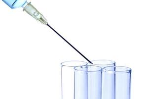 Syringe putting liquid in test tubes photo