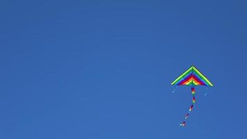 Colorful Kite Flying In Cloudless Blue Sky