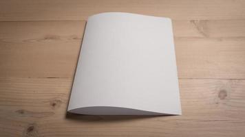 White blank folded paper on wooden table photo