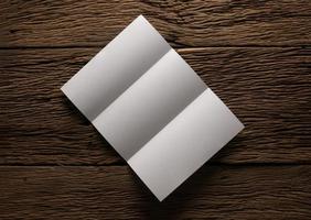 White blank folded paper on wooden table photo