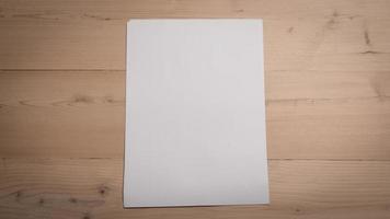 White blank folded paper on wooden table photo