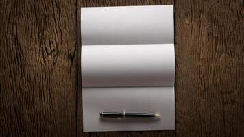 Hoja de papel en blanco y lápiz sobre una mesa de madera foto