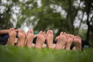 Close-up of family feet together on a green field