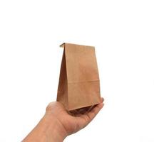 Hand holding brown paper bag photo