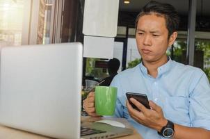 Business man holding phone and coffee photo