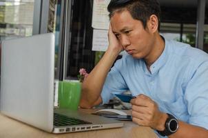 Man holding credit card and looking at laptop photo