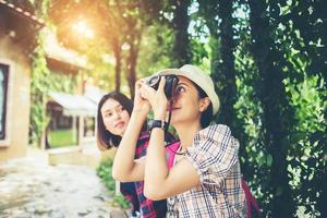 Two woman having a good time while sitting at bench photo