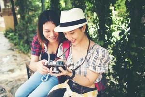 Two woman having a good time while sitting at bench photo