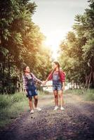 Two girls walking along a forest road photo