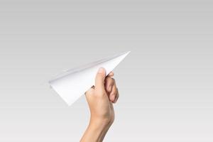 Woman's hand holding a paper airplane isolated on white background photo