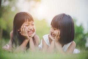 Little girls lying comfortably on the grass and smiling photo