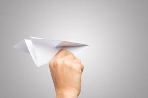 Woman's hand holding a paper airplane isolated on white background photo