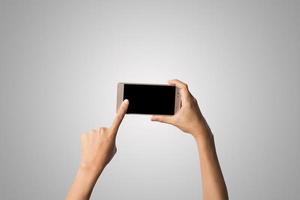 Close-up de la mano de una mujer sosteniendo un teléfono aislado sobre fondo blanco. foto