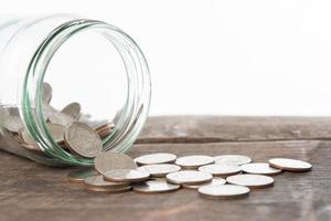 Saving money concept of collecting coins on a wooden background photo