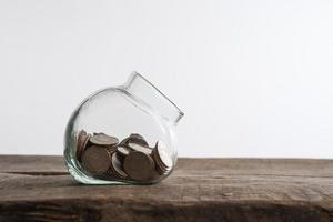 Saving money concept of collecting coins on a wooden background photo