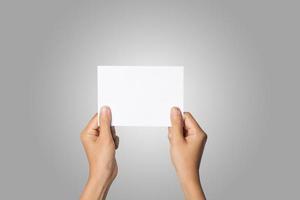 Close-up of a woman's hand holding blank paper isolated on white background photo