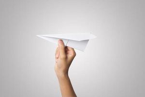 Woman's hand holding a paper airplane isolated on white background photo