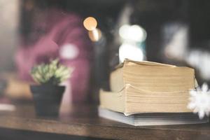 Cactus flower with a stack of books on wood table photo