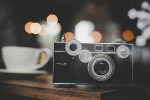 Cámara vintage o retro en una mesa de madera en un café foto