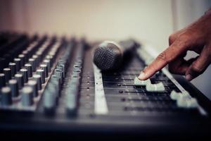 Hands of sound engineer adjusting audio mixing console photo