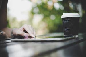 primer plano, de, un, mujer, utilizar, un, tableta, computadora, en, tabla de madera foto