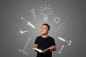 A boy and a book of knowledge on a blackboard background photo