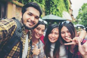 Grupo de amigos tomando un selfie en una calle urbana divirtiéndose juntos foto