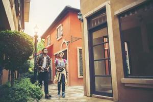 Couple of young tourists walking in an urban city enjoying holiday together photo