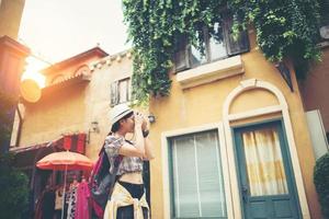 Portrait of a young hipster woman traveling and taking photos in the city