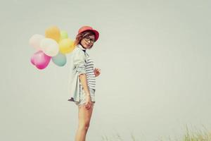 Young beautiful woman holding balloons in the fresh air photo