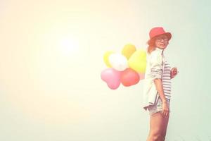 Young beautiful woman holding balloons in the fresh air photo