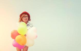 joven y bella mujer sosteniendo globos al aire libre foto