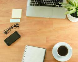 Flat lay of desk with plant, coffee, and phone photo