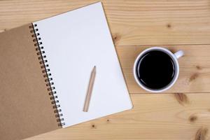 Top view of a notebook and coffee on a table photo