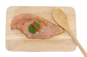 Marinated chicken on a wooden chopping board photo