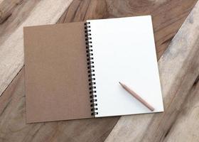 Notebook and pencil on wooden table photo