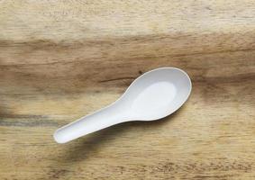 Plastic spoon on wood photo