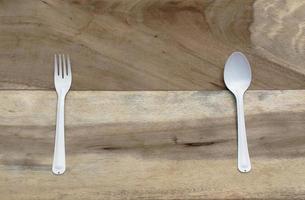 cuchara y tenedor sobre fondo de madera foto