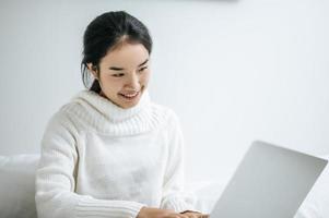 mujer joven feliz jugando en su computadora portátil