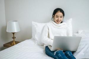 mujer joven feliz jugando en su computadora portátil
