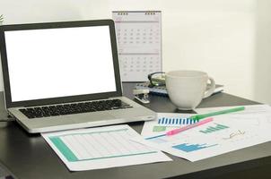 Messy desk with charts and coffee photo