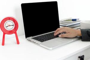 Laptop with clock on desk photo