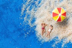 Miniature figurines sitting on the beach photo