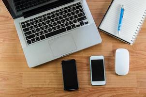 portátiles y teléfonos inteligentes en el escritorio foto