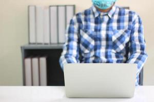 Person wearing mask while working photo