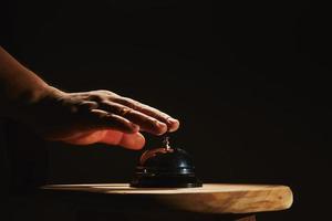 Hand ringing bell on a stool photo