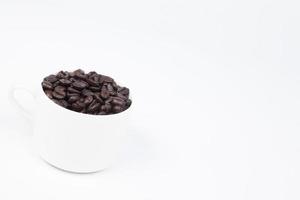 Cup with coffee beans on white background photo