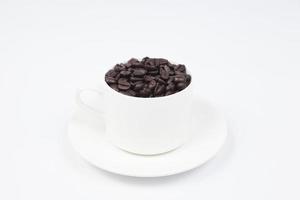 Cup with coffee beans on white background photo