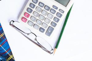 Calculator, glasses, pencil and protractor scale. photo