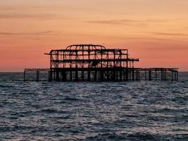 Metal pier in body of water with colorful cloudy sky photo
